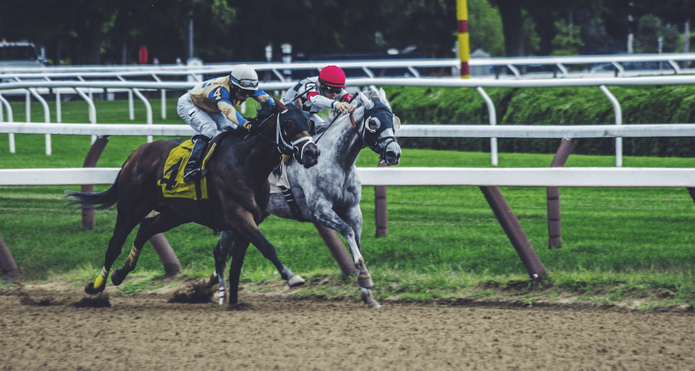 Jockeys riding horses at a major racetrack