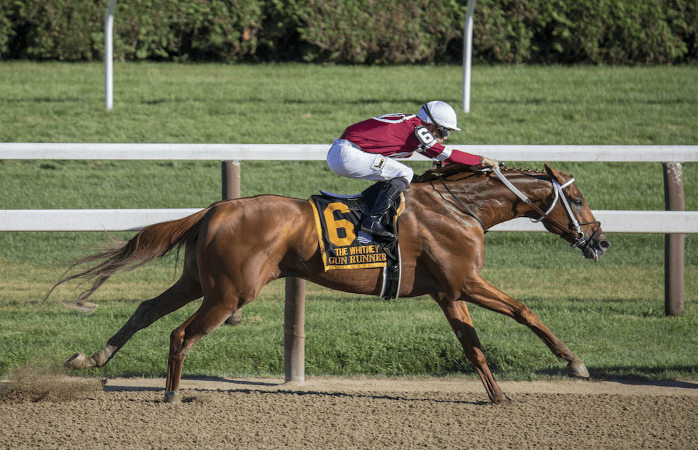 A jockey riding a horse at a major racetrack in Saratoga